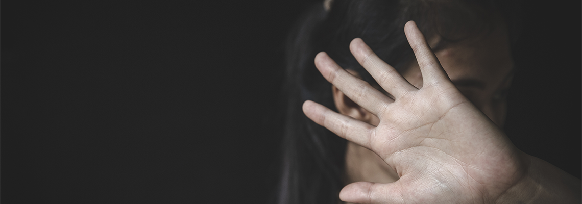 A woman holds her hand out in front of her face