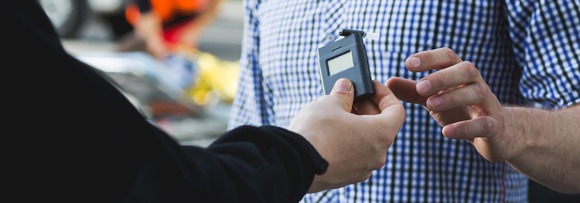 Policeman Giving a Breathalyzer to A Driver