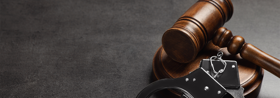 Judge's Gavel and Handcuffs on Grey Background