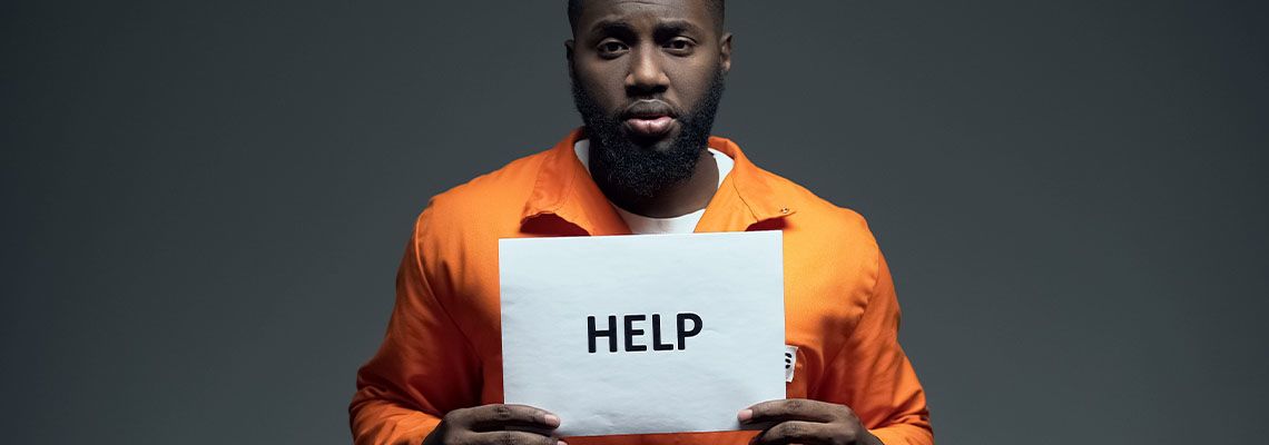 African-american male prisoner holding help sign