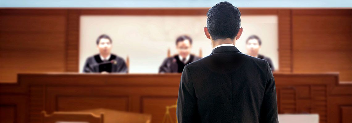 Trial attorney standing before judge bench in courtroom
