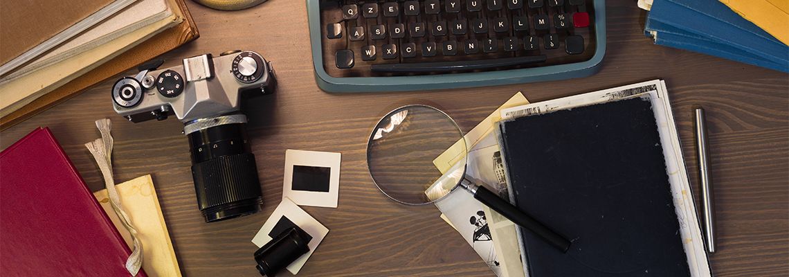 Desk with documents, typewriter, camera, magnifying glass