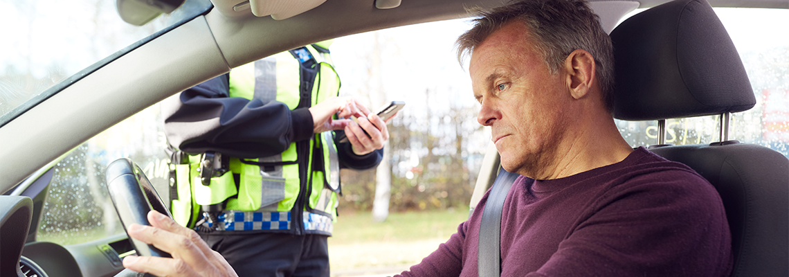 Driver Being Stopped By Female Traffic Police Officer With Digital Tablet