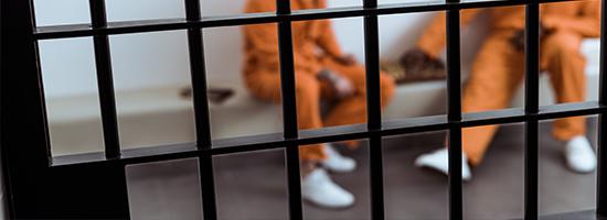 multicultural prisoners playing chess behind prison bars